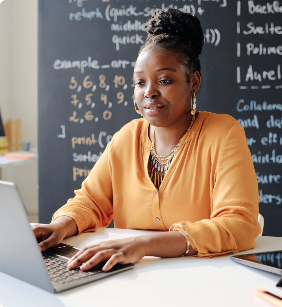 Photo of a teacher typing on a laptop computer