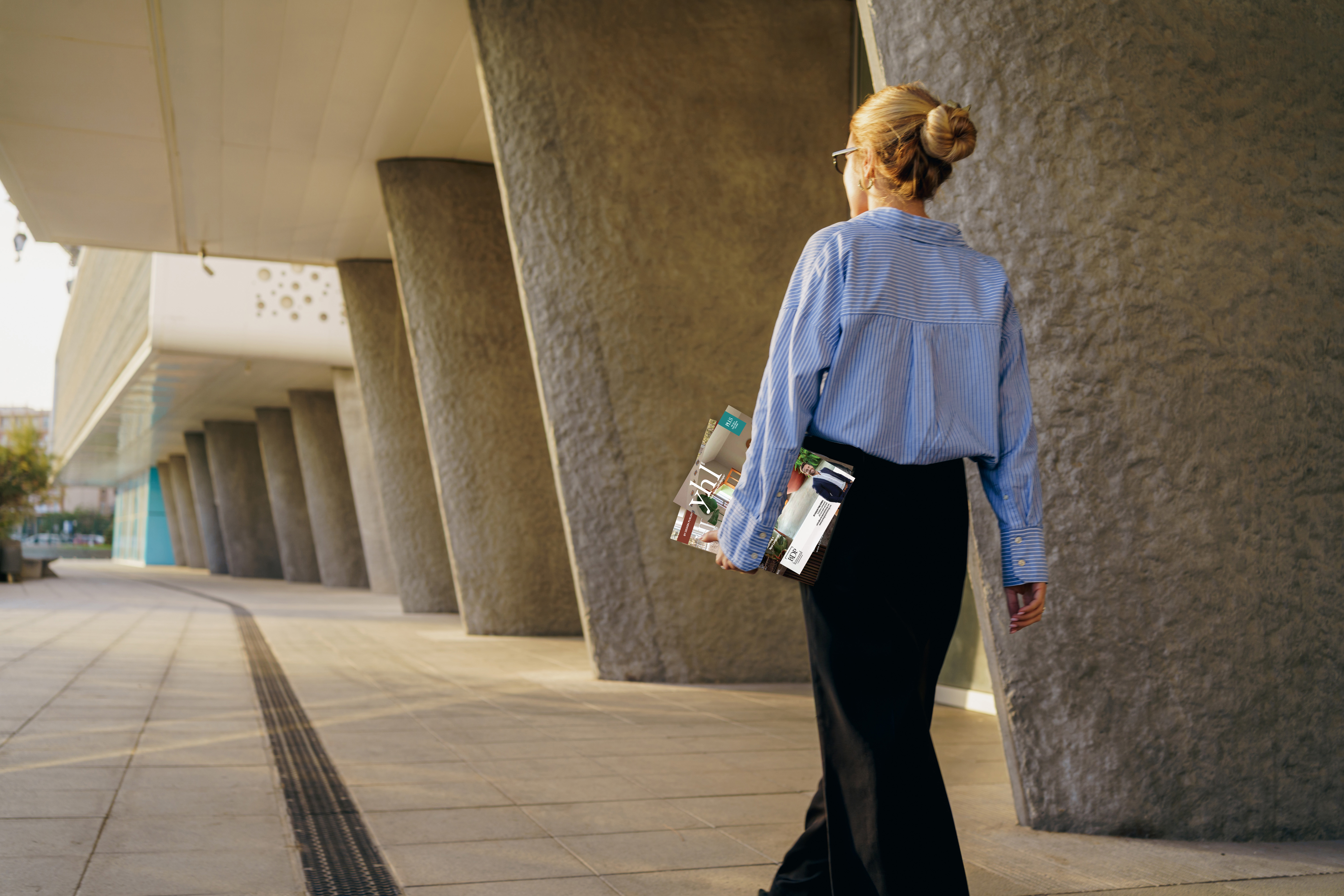 Real estate professional carrying personalized marketing materials to support local marketing, customer engagement, and brand visibility in a changing real estate market.