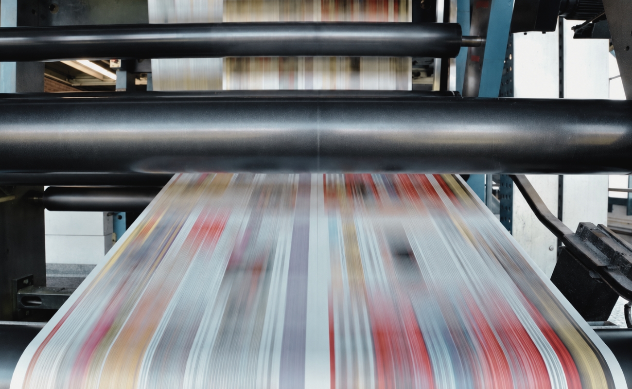 Commercial printing presses in a manufacturing facility representing production-biased managed services and marketing execution.