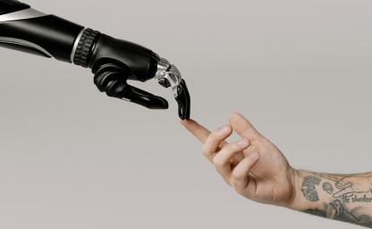 Robotic hand touching a human finger, symbolizing the role of AI and human judgment in marketing execution, campaign management, and integrated execution within creative services. 
