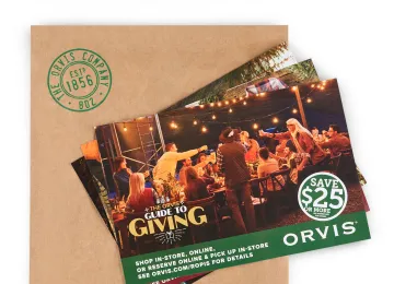 Orvis promotional mailer with a holiday catalog and coupon placed on a branded envelope.